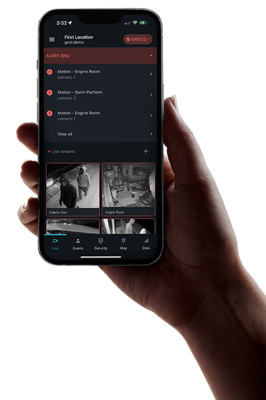Hand holding a phone running Specter AI showing live alerts and camera feeds.